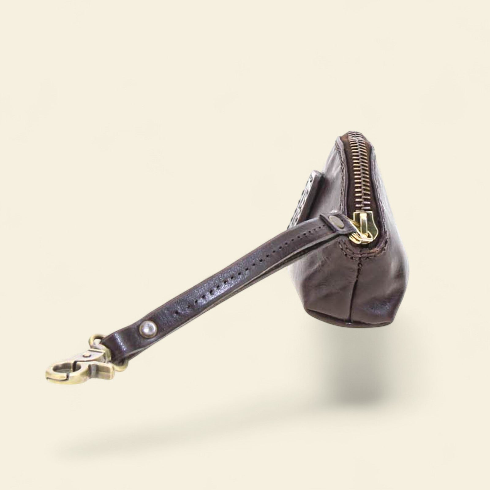 Black leather coin purse with a visible brand logo on a beige background