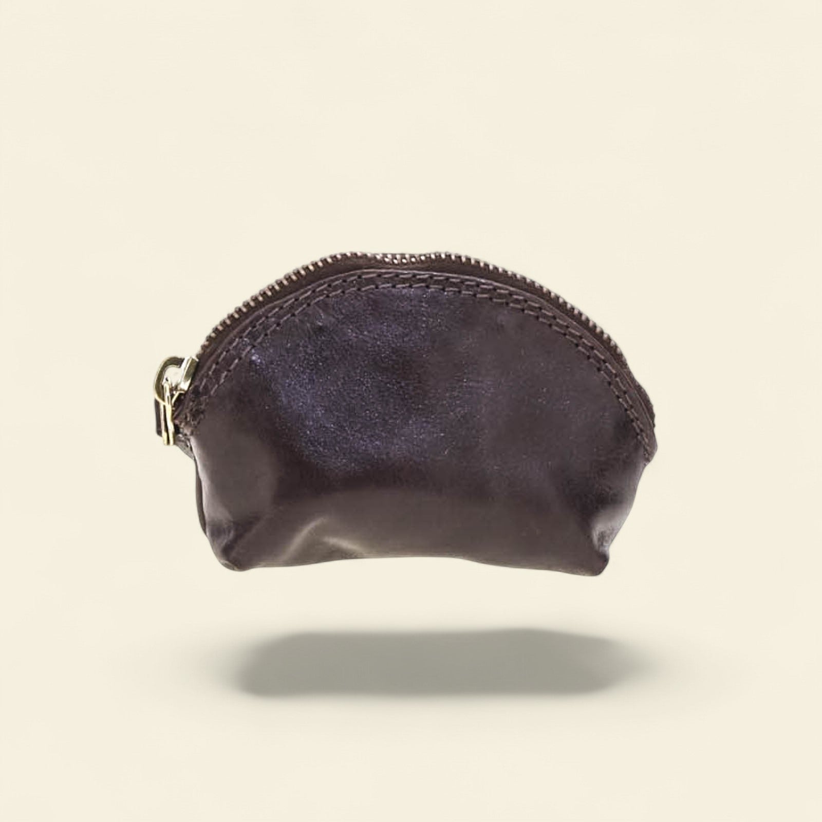 Black leather coin purse with a visible brand logo on a beige background