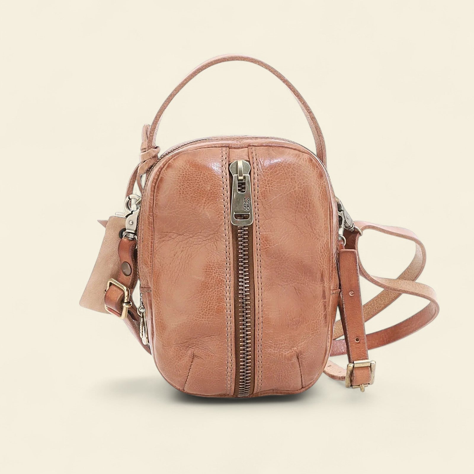 Brown leather crossbody bag on a beige background