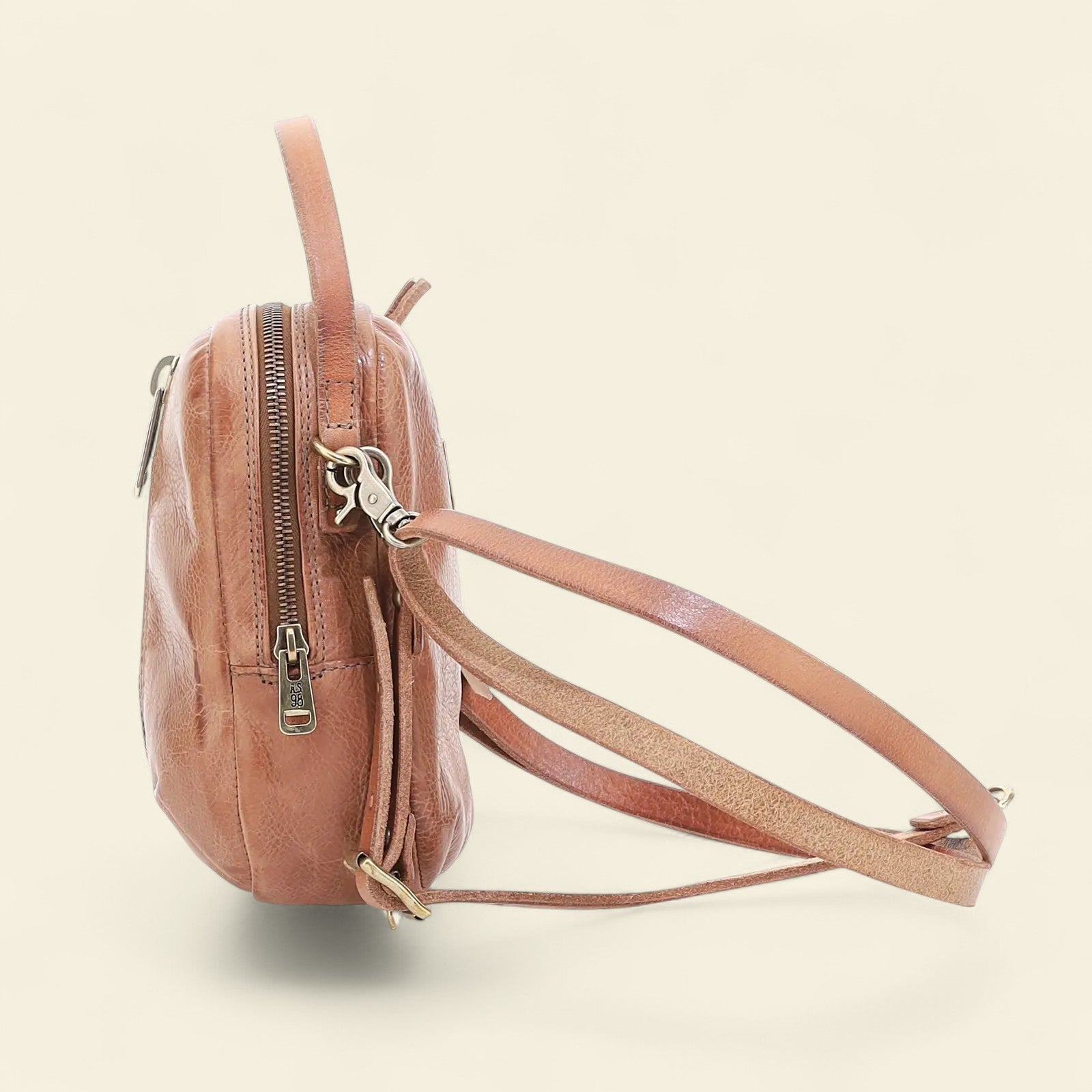 Brown leather crossbody bag on a beige background