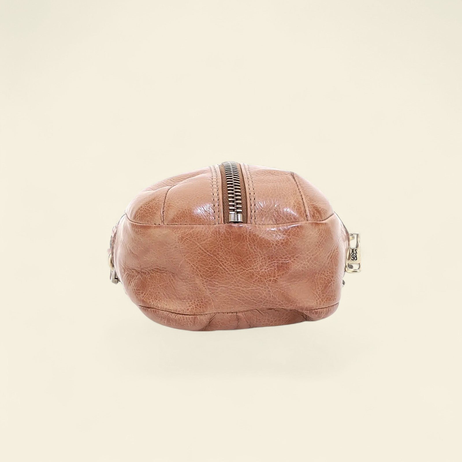 Brown leather crossbody bag on a beige background
