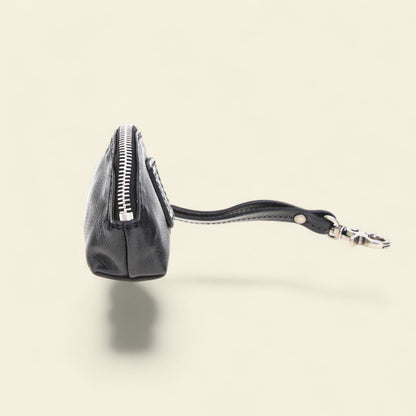 Black leather coin purse with a visible brand logo on a beige background 