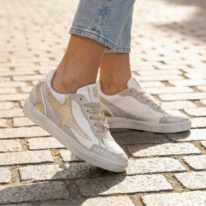 Close-up of A.S.98 white leather sneakers on cobblestone street