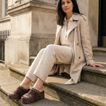 Woman wearing A.S.98 brown leather platform sandals sitting outdoors #color_ebony
